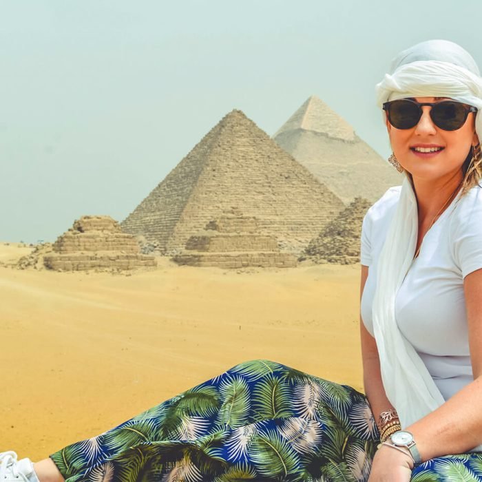 A-stunning-photo-of-a-tourist-sitting-in-front-of-the-pyramids